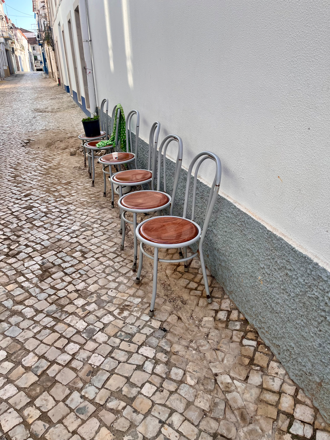 Chairs lined up outside on a tiled street