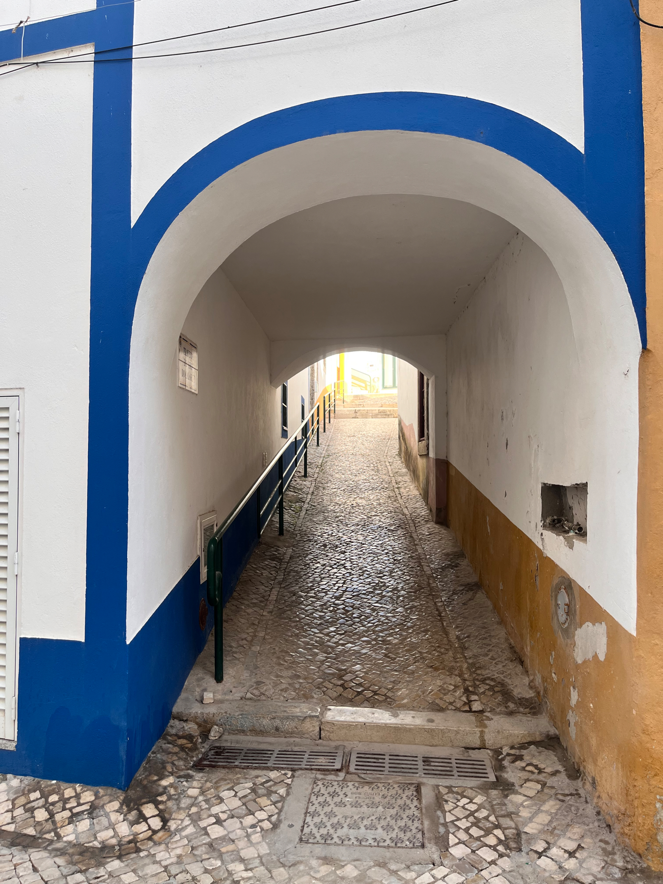 Archway, painted blue trim with white as the main color, on a town footpath