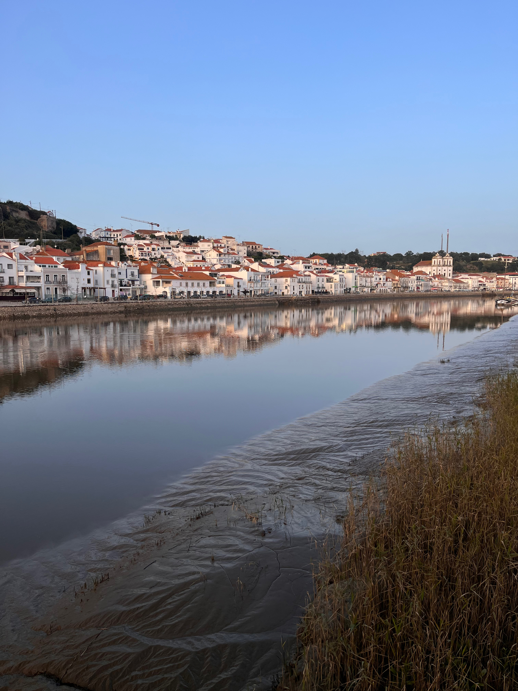 Alcácer do Sal, Portugal, from over the River Sado. The river is so still that the town is reflected in the river.