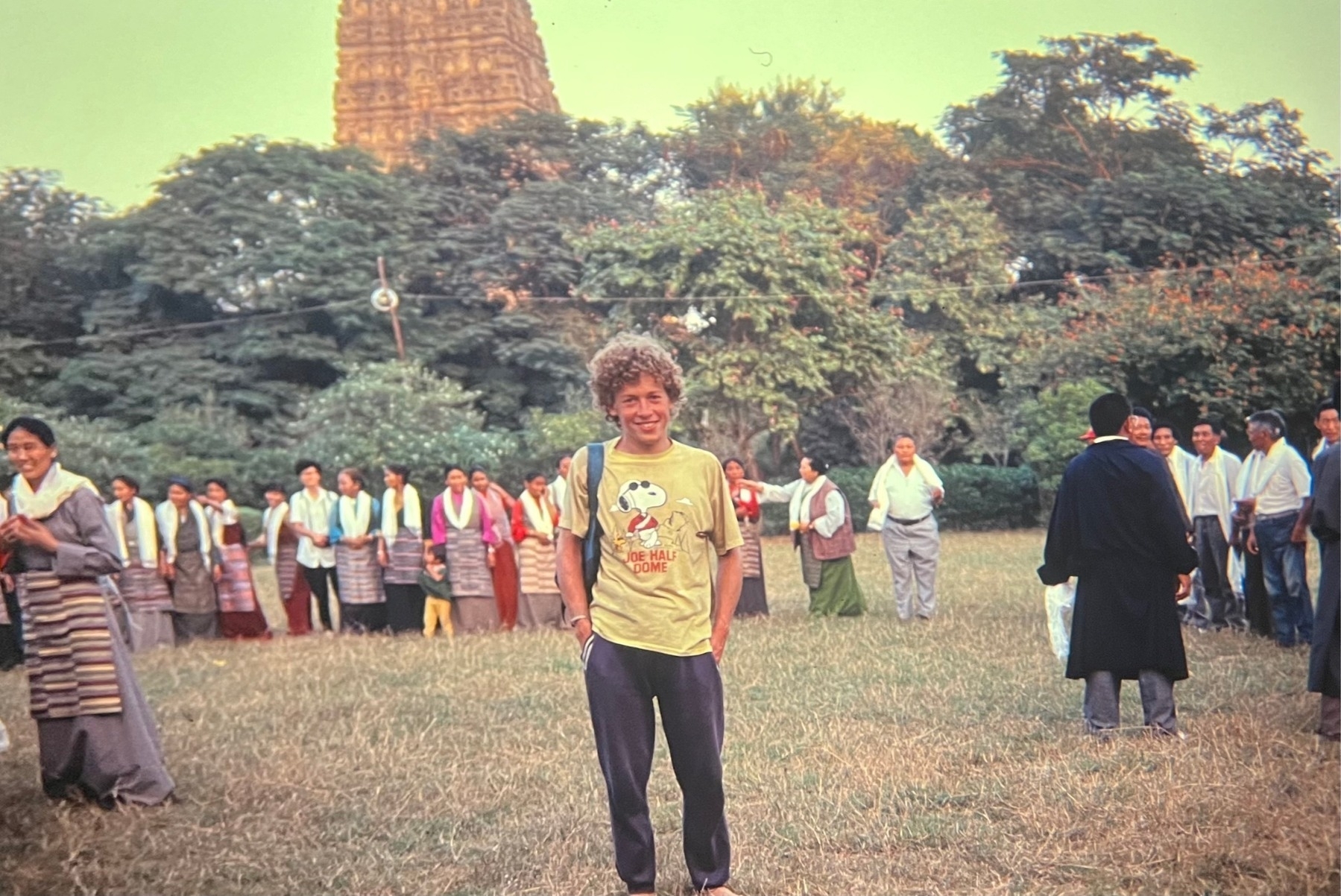 Me with Tibetan people in a field and the Mahabodhi Temple behind