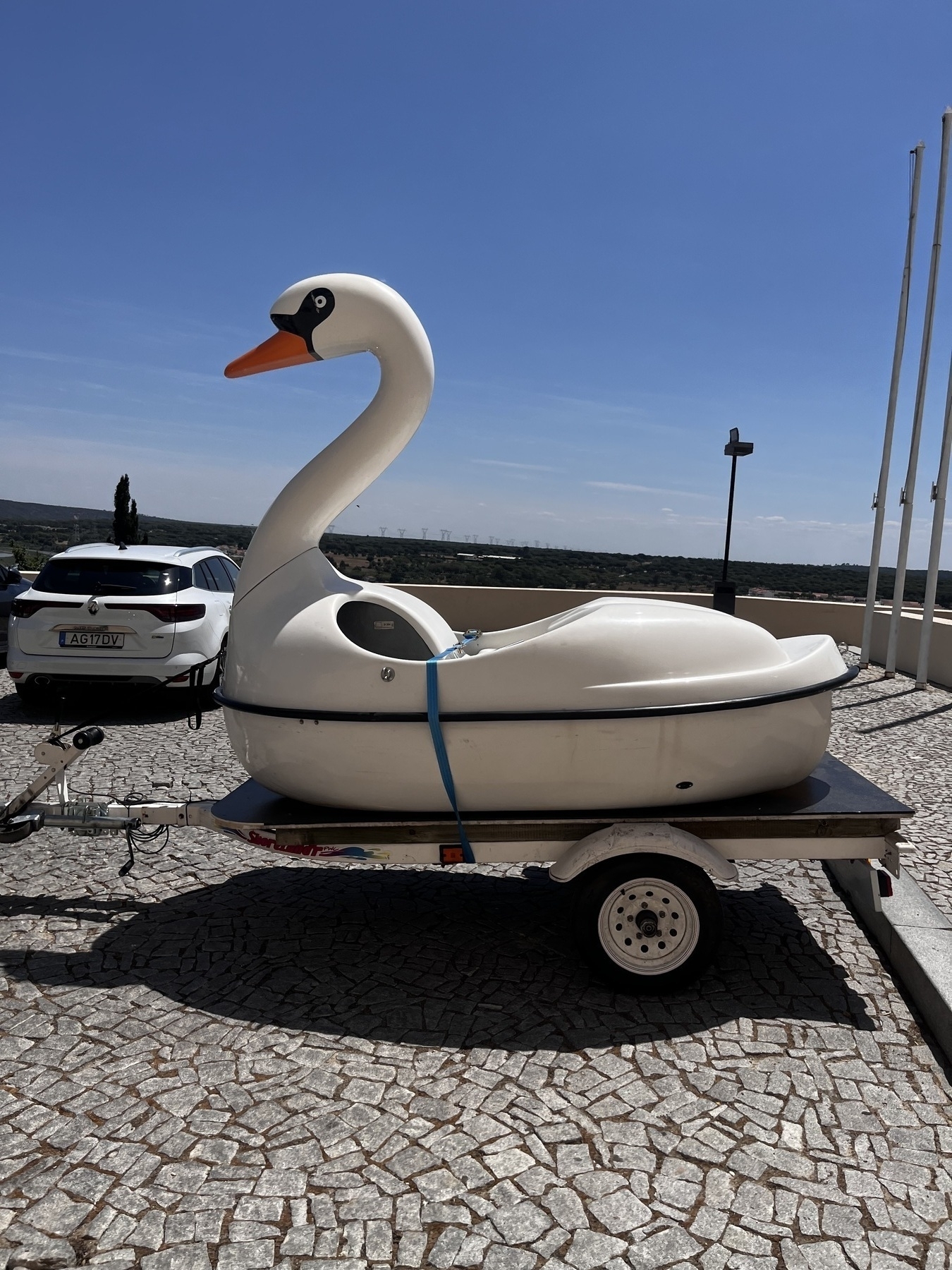 A large plastic model of a swan on a trailer.
